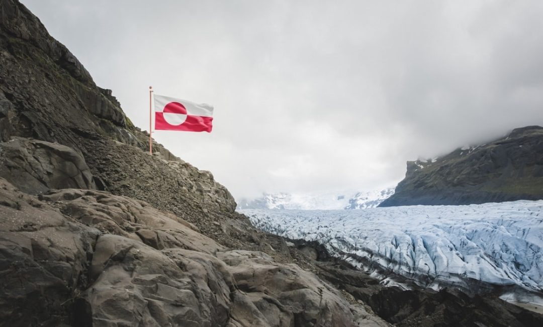 Greenland,National,Flag,Flies,Above,A,Rocky,Arctic,Glacier,And